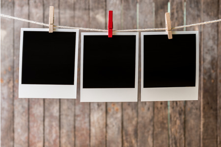 Three blank instant photos hanging on the clothesline.Clipping path for insert Photoの写真素材