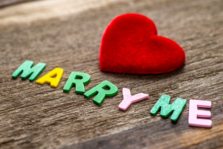 Marry me message written by colour paper near red heart. Wooden Background,Selective focusの写真素材
