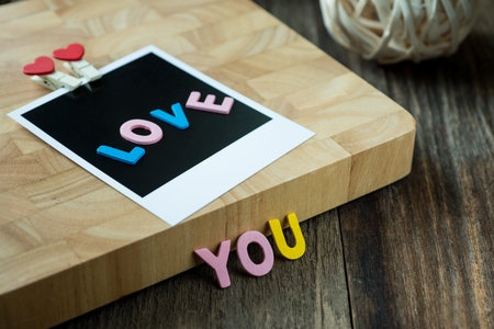 Love you message on Blank instant photo over old wooden background,selective focusの写真素材