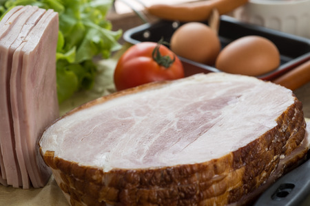 smoked meat and sausages with tomato and eggs on a wooden, selective focusの写真素材