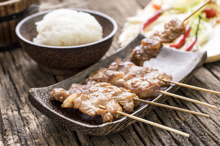 grilled pork with sweet spicy sauce and sticky rice on wooden plate: Thai street food styleの写真素材