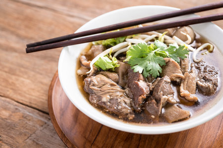 Close up of a bowl of Chinese style beef noodle soup, selective focus