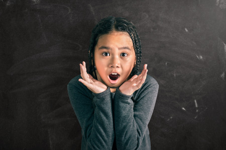 Close up of  a little amazing girl ,dreadlocks hair style,on blackboard backgroundの写真素材