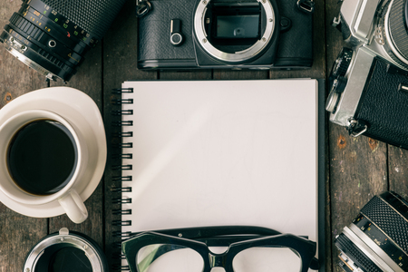 Top view of retro camera and lens with blank paper, set of cool photography on wooden background,Voyage conceptの写真素材