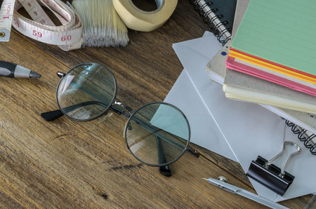 Desk of an artist with lots of stationery objects. Studio shot on wooden background,View from above.の写真素材