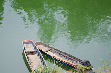 Rowing boat leaks immersed in water.の写真素材