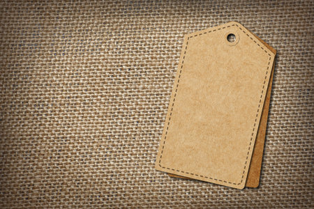 background of burlap hessian sacking with blank paper tagの写真素材