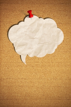blank speech bubble note paper with push pins on cork boardの写真素材