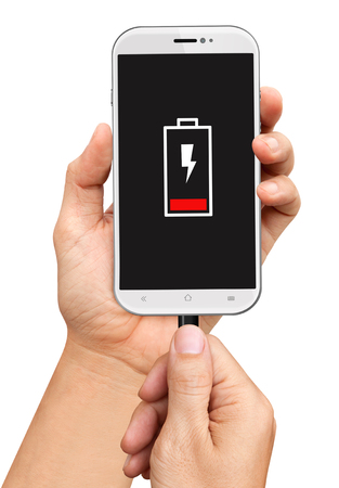 Hand holding low battery smartphone and connect charger isolated on white backgroundの写真素材