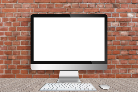 Modern Computer on wood table with red bricks wall backgroundの写真素材