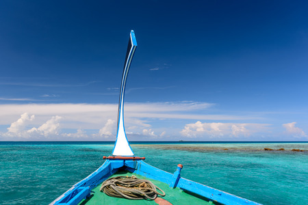 Head of boat floating in deep blue sea in Maldivesの写真素材