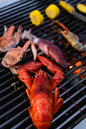 Lobster, crab, squid, prawn on charcoal grillの写真素材