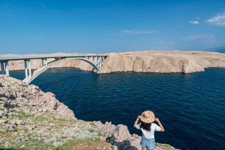 Concept picture of traveling. Woman looking at scenic view by the sea at pag island in Croatia,