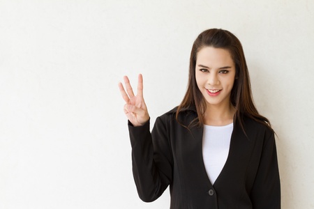 woman business executive showing 3 or three fingers hand gestureの写真素材