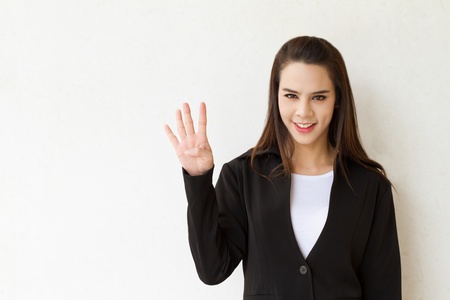 woman business executive showing 4 or four fingers hand gestureの写真素材