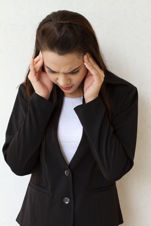 woman with headache, migraine, stress, insomnia, hangover in business executive dressの写真素材