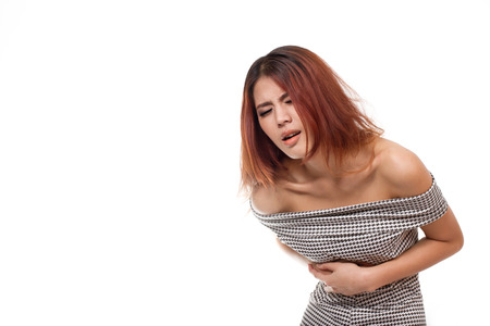 menstruation pain or stomach trouble, woman hand holding her belly white isolated backgroundの写真素材