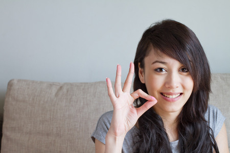woman giving ok hand sign, asian caucasian mixed raceの写真素材