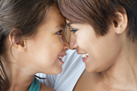 portrait of happy, smiling, positive family  mother and daughter sharing loving and careの写真素材