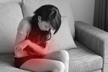 menstruation pain, period cramp, stomach ache, digestive problem of woman in indoor sceneの写真素材