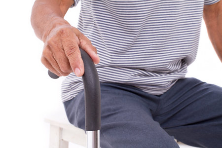senior hand holding walking stick