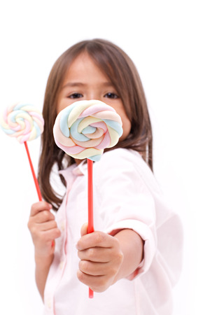 little girl giving sweet marshmallow candy to youの写真素材