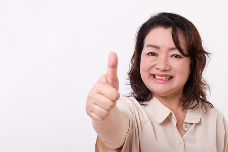 confident, successful middle aged woman showing thumb up hand gestureの写真素材