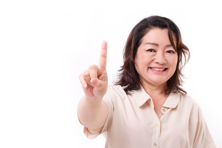 happy, confident middle aged woman pointing up one finger, number 1 hand sign gestureの写真素材