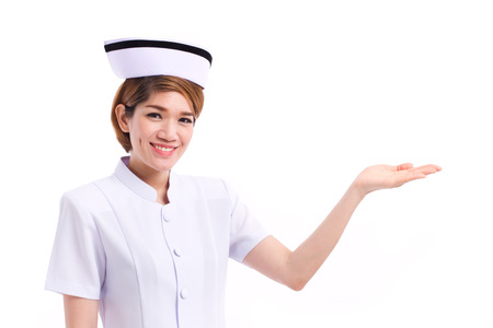 smiling female nurse presenting, showing her hand to blank space, studio isolated of asian woman modelの写真素材