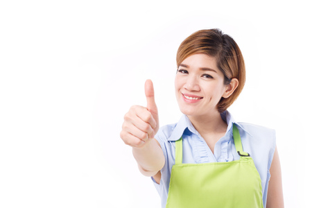 happy woman with apron showing thumb up hand gestureの写真素材
