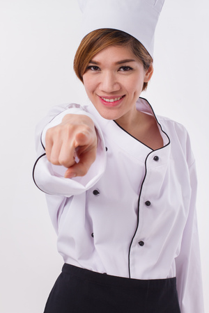 happy female asian chef pointing at youの写真素材