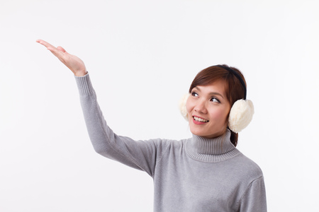 happy, smiling, positive asian woman pointing and looking up, in fall or winter styleの写真素材