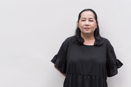 tired middle age asian woman in black dressの写真素材