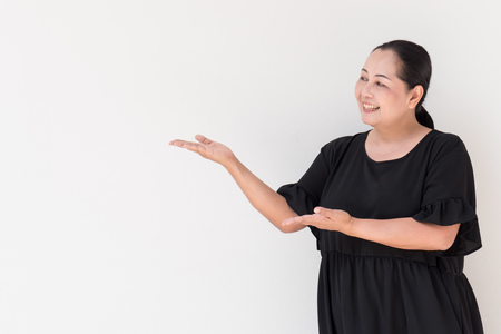 middle age woman pointing up, showing, suggesting, presenting somethingの写真素材