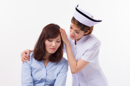female nurse treating sick patient, headache, stress, hangover, feverの写真素材