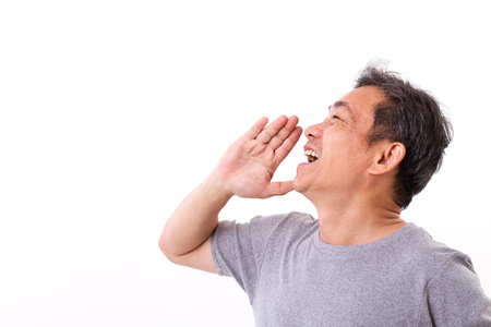 happy middle aged man senior uncle shouting, speaking, advertising, communicating to blank spaceの写真素材