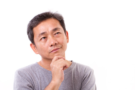 middle aged asian man thinking, studio isolated portraitの写真素材