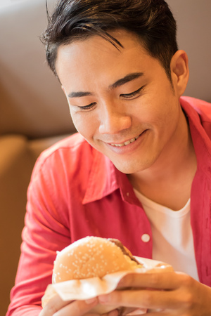 man eating burger, concept of unhealthy junk food, fast foodの写真素材