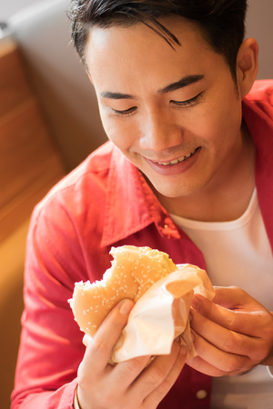 man eating burger, concept of unhealthy junk food, fast foodの写真素材
