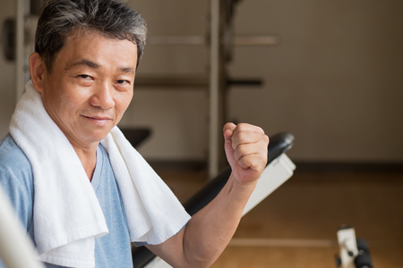strong, healthy, happy, smiling, positive senior well being asian man working out in gymの写真素材