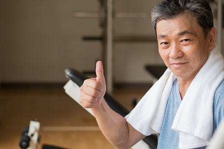 healthy, happy senior man working out in gym, giving thumb up gestureの写真素材
