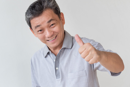 happy, successful, positive middle aged man showing thumb upの写真素材