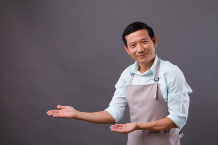 confident man shopkeeper pointing hand up to space, concept of small business owner, shop manager, entrepreneur suggesting somethingの写真素材