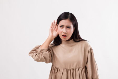 sad frustrated unhappy woman listening ear to bad news or having hearing impair, hard of hearingの写真素材