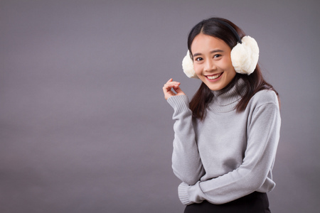 happy smiling asian woman with earmuffsの写真素材