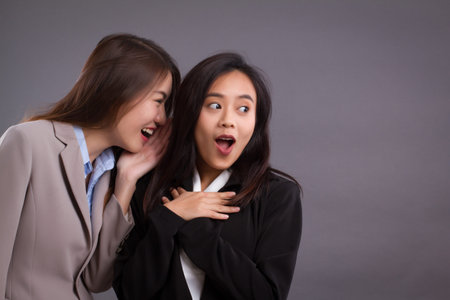Business woman gossiping, spreading good news, secret or rumorの写真素材
