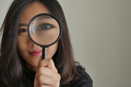 woman searching, viewing, finding with magnifying glass, girl searching conceptの写真素材