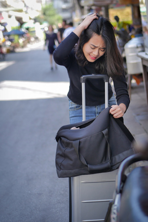 sad, negative woman traveler or tourist getting lost her money, belongings, passport due to pickpocketing or theft during travel, having bad travel experienceの写真素材