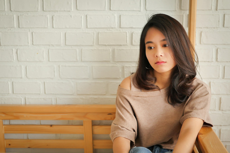 absent-minded woman sitting in apartmentの写真素材