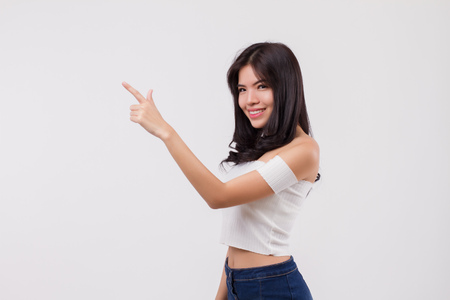Happy smiling woman pointing up portrait, positive optimistic woman point finger or hand studio white isolated portrait, young adult beautiful girl asian woman modelの写真素材